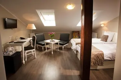 a hotel room with a bed and a desk and a table at Leone Aparthotel in Kraków