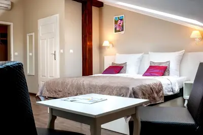 a hotel room with a bed and a table at Leone Aparthotel in Kraków