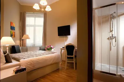 a bedroom with a bed and a desk and a television at Leone Aparthotel in Kraków