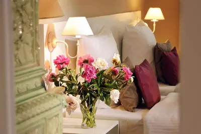 a vase of flowers on a table in a hotel room at Leone Aparthotel in Kraków