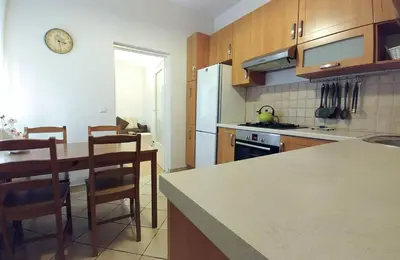 a kitchen with a table and a refrigerator and chairs at Apartament Oficyna in Kraków