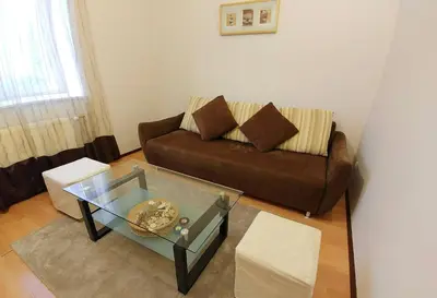 a living room with a couch and a glass table at Apartament Oficyna in Kraków
