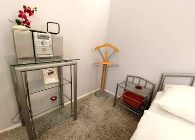 a bedroom with a bed and a table with a radio at Apartament Oficyna in Kraków