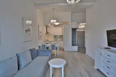 a living room and kitchen with a couch and a table at RAJSKA 3 by PI Apartments in Kraków