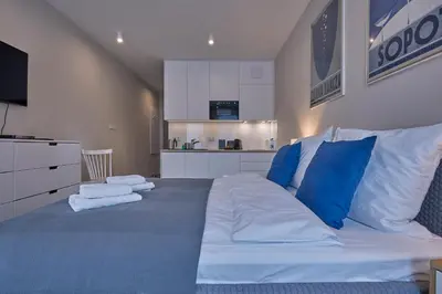 a bedroom with a large bed with blue and white pillows at RAJSKA 3 by PI Apartments in Kraków