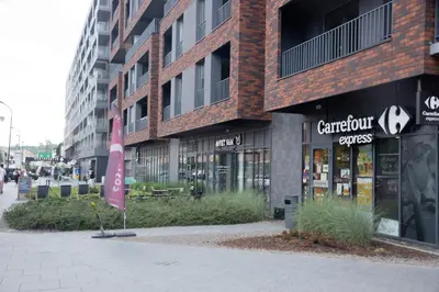 a building with a pink sign in front of it at Unique apt EVE - free garage in Kraków