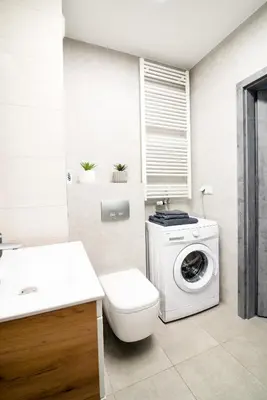 a bathroom with a washing machine and a toilet at Unique apt EVE - free garage in Kraków