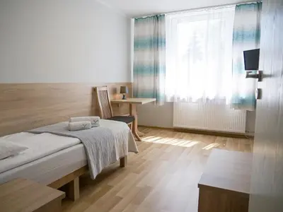 a bedroom with a bed and a desk and a window at CKS Kraków (Centrum Konferencyjno-Szkoleniowe CS Natura Tour) in Kraków