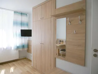 a large wooden cabinet with a mirror in a room at CKS Kraków (Centrum Konferencyjno-Szkoleniowe CS Natura Tour) in Kraków