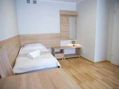 a small bedroom with a bed and a desk at CKS Kraków (Centrum Konferencyjno-Szkoleniowe CS Natura Tour) in Kraków