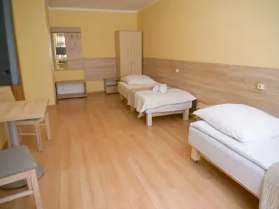 a hospital room with two beds and a table at CKS Kraków (Centrum Konferencyjno-Szkoleniowe CS Natura Tour) in Kraków