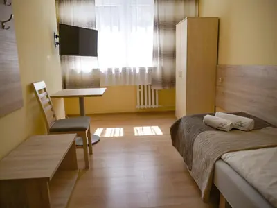 a bedroom with a bed and a desk and a table at CKS Kraków (Centrum Konferencyjno-Szkoleniowe CS Natura Tour) in Kraków