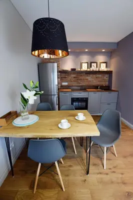 a kitchen and dining room with a wooden table and chairs at Jewish Quarter Comfort - In City Apartments in Kraków