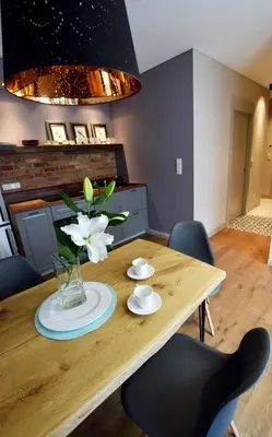 a dining room table with a vase of flowers on it at Jewish Quarter Comfort - In City Apartments in Kraków