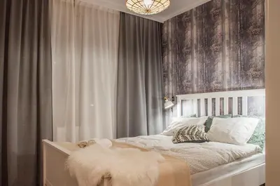 a bedroom with a bed with gray curtains and a chandelier at Brown Sugar | free garage | 2 separate rooms in Kraków