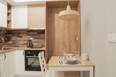 a kitchen with a table with glasses and a chandelier at Brown Sugar | free garage | 2 separate rooms in Kraków