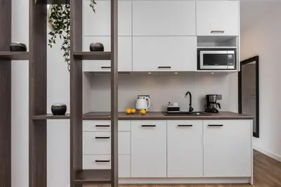 a kitchen with white cabinets and a microwave at Rajska 3 by Atrium Apartments in Kraków