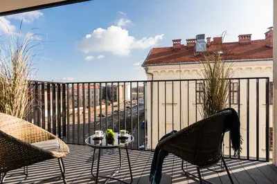a patio with two chairs and a table on a balcony at Rajska 3 by Atrium Apartments in Kraków