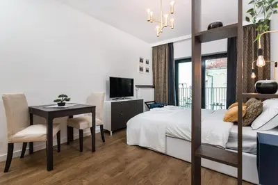 a bedroom with a bed and a desk and a television at Rajska 3 by Atrium Apartments in Kraków