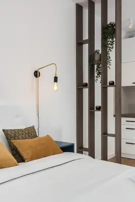 a bedroom with a bed and a lamp and shelves at Rajska 3 by Atrium Apartments in Kraków