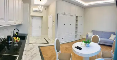 a living room with a table and a blue couch at Tresor Barska Apartments in Kraków