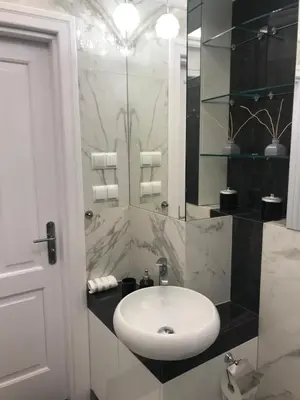 a bathroom with a white sink and a shower at Tresor Barska Apartments in Kraków