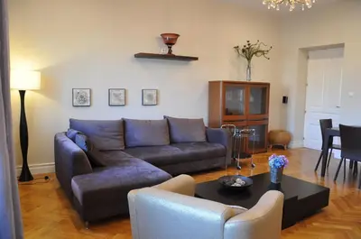 a living room with a blue couch and a table at Tresor Barska Apartments in Kraków