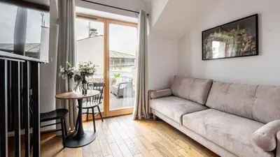 a living room with a couch and a table at Aparthotel Delta Boutique in Kraków