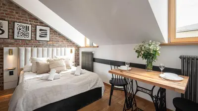 a bedroom with a bed and a wooden table at Aparthotel Delta Boutique in Kraków