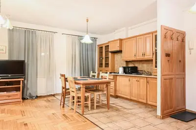 a kitchen with a table and chairs and a television at D&A Apartments Szewska in Kraków