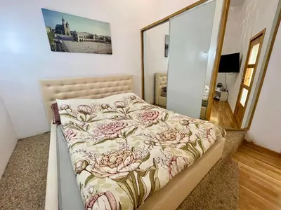 a bedroom with a bed with a floral bedspread at XXL Apartment Old Town 24 h - check in, Wi-Fi in Kraków