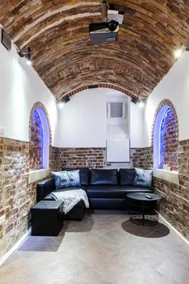 a living room with a couch and a brick wall at XXL Apartment Old Town 24 h - check in, Wi-Fi in Kraków