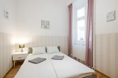 a white bedroom with a bed and a window at XXL Apartment Old Town 24 h - check in, Wi-Fi in Kraków