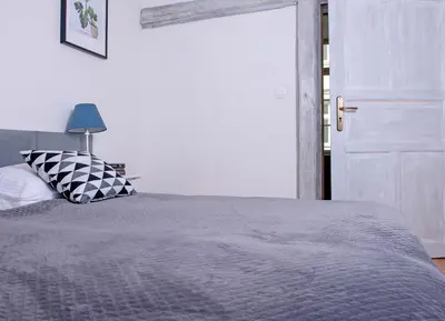 a bedroom with a bed with a gray comforter at 3D FLORIANSKA 15 Apartament in Kraków