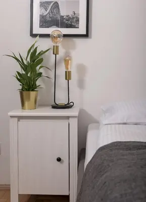 a nightstand with a lamp on it next to a bed at 3D FLORIANSKA 15 Apartament in Kraków