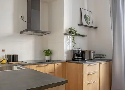 a kitchen with wooden cabinets and a counter top at 3D FLORIANSKA 15 Apartament in Kraków