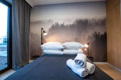 a bedroom with a bed with towels on it at City Lights Rakowicka 15 in Kraków
