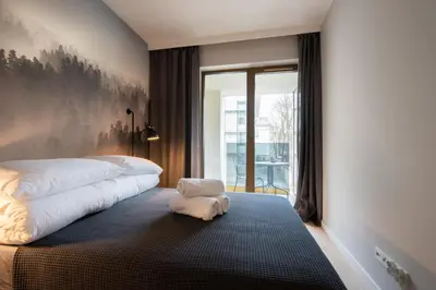 a bedroom with a bed with a white pillow on the floor at City Lights Rakowicka 15 in Kraków