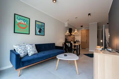 a living room with a blue couch and a table at City Lights Rakowicka 15 in Kraków