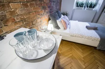 a room with glasses on a table with a bed at LION apartments in Kraków
