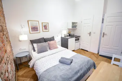 a small bedroom with a bed and a kitchen at LION apartments in Kraków