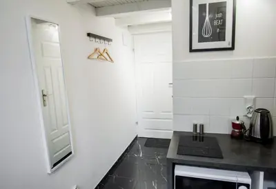 a kitchen with white walls and a black counter top at LION apartments in Kraków