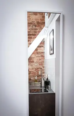 a kitchen with a sink and a brick wall at LION apartments in Kraków