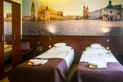 two beds in a room with a view of a city at Vinci Hotel Airport in Modlniczka