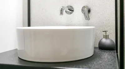 a white sink sitting on a black counter top at Camera Apartments in Kraków