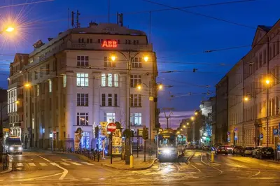 a building on a city street at night at Camera Apartments in Kraków