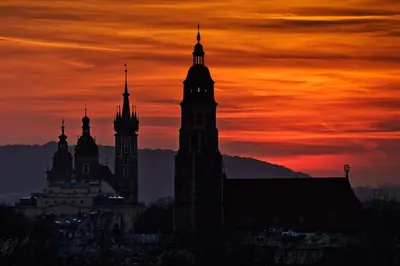 a group of buildings with a sunset in the background at Camera Apartments in Kraków