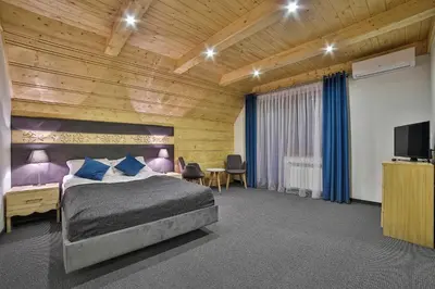 a bedroom with a bed and a tv in a room at Hotel&SPA Jawor in Zawoja