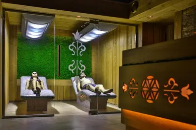 two people sitting in chairs in front of a green wall at Hotel&SPA Jawor in Zawoja