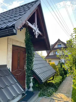a house with a brown door with ivy on it at Domek pod Maciejową in Rabka